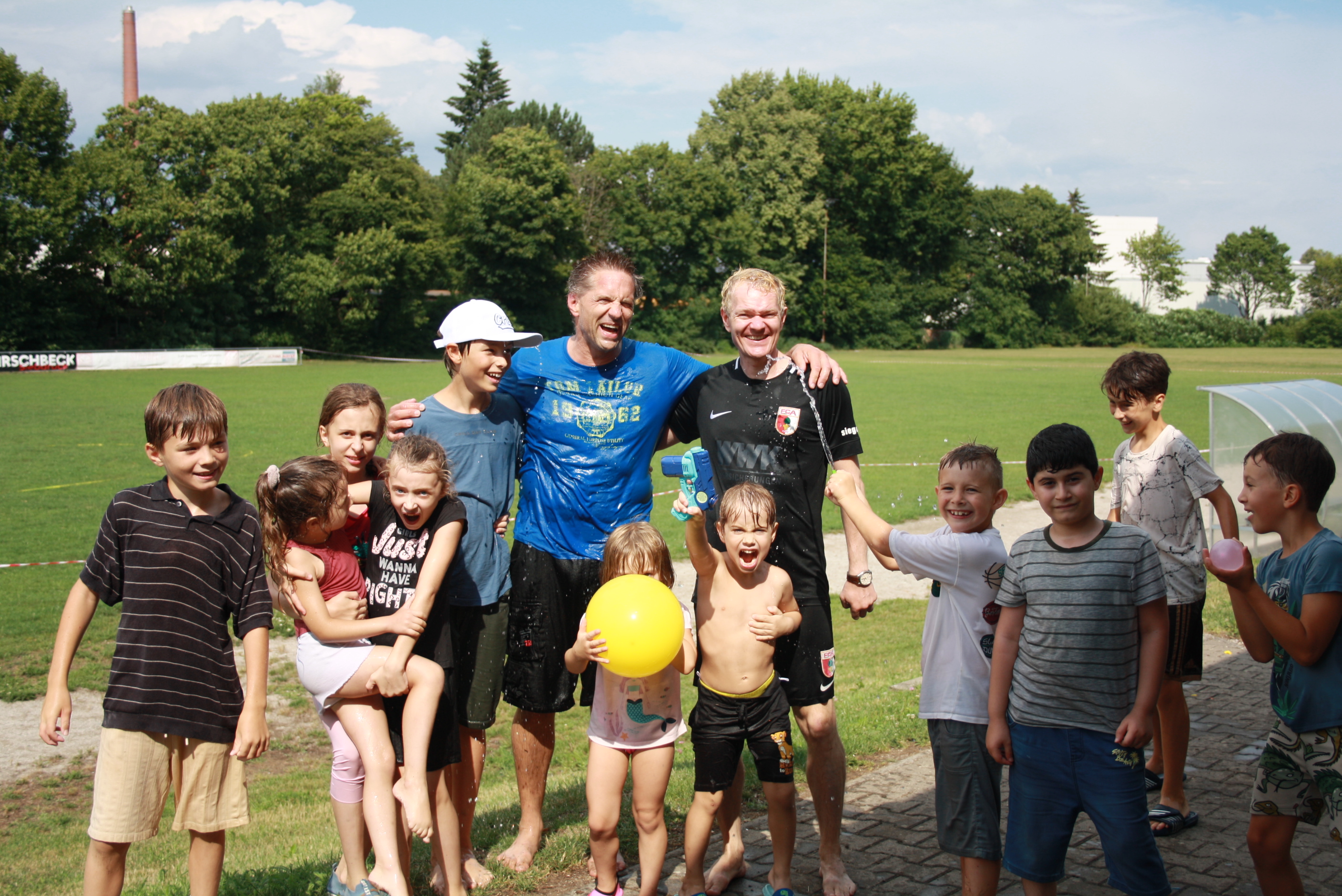 Nasse Trainer und nasse kleine Karatekas nach der Wasserschlacht